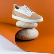 right white and brown sneaker placed on top of two stones