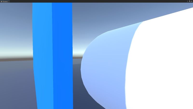 A white capsule beside a blue wall in Unity.