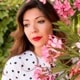 dark-haired caucasian woman in white polka-dot blouse